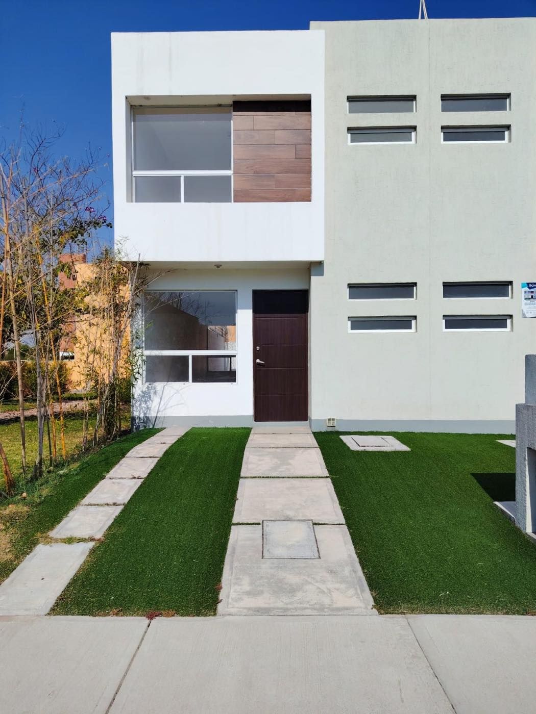 Fachada del modelo Girasol Plus con jardín y andador de entrada