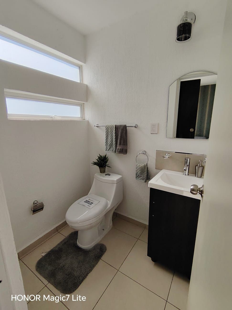Medio baño de planta baja con lavabo y ventana alta
