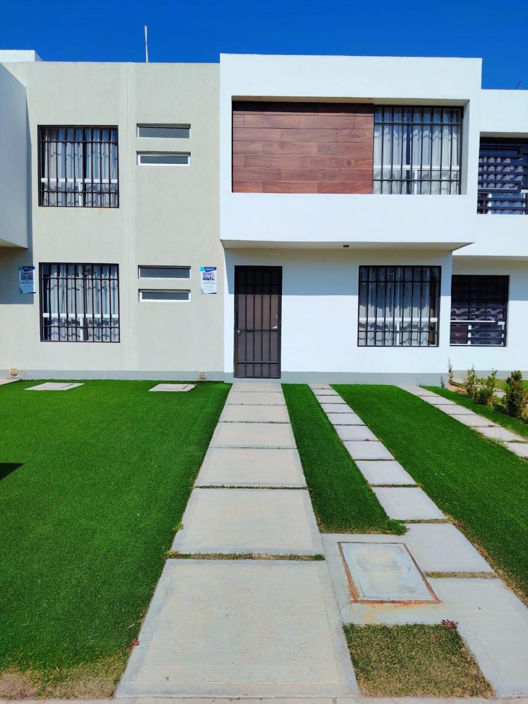 Fachada del modelo Orquídea con jardín y andador de entrada