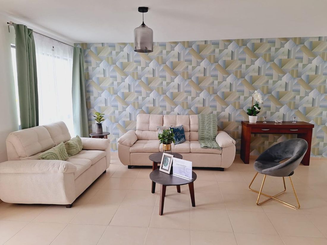 Sala amplia con muro empapelado en tonos verdes y azules