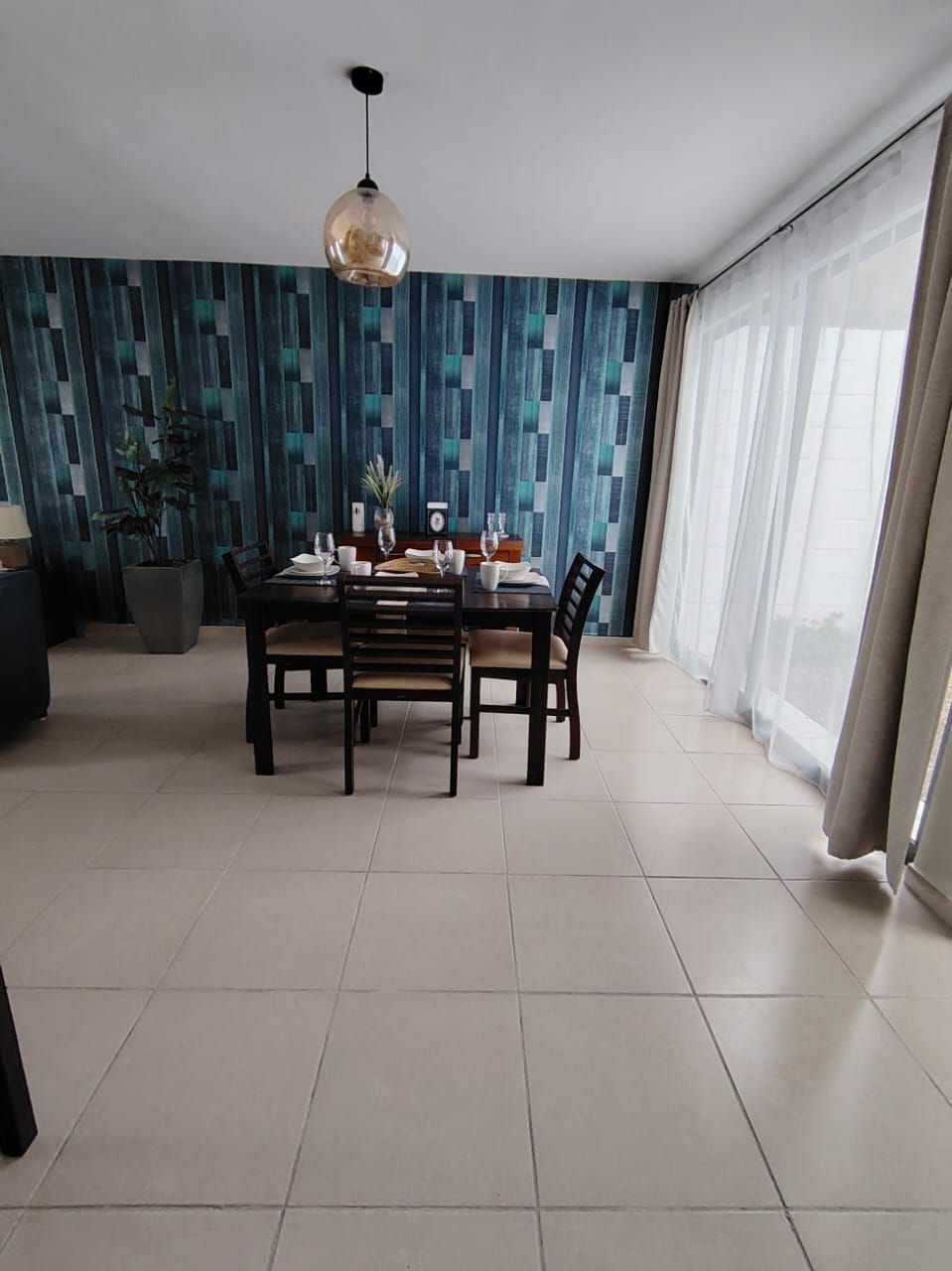 Comedor junto al ventanal, con el mismo muro azul